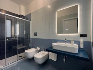 a bathroom with a sink and a toilet and a mirror at Palazzo Zippitelli Apartments in Bari