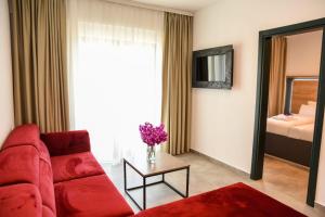 sala de estar con sofá rojo y mesa en Apartments Montenegro Hills Ulcinj en Ulcinj