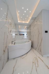 a bathroom with a white tub and marble walls at Rei Lux in Belgrade