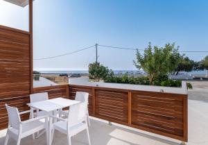 un patio con mesa y sillas y vistas al océano en Long Beach Resort, en Ierápetra