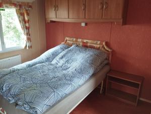 un letto in una camera da letto con piumone blu e bianco di Ośrodek Wypoczynkowy "Marina Rozbejko" a Myślibórz