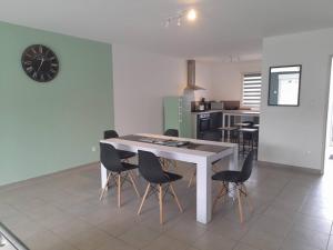 een keuken met een tafel en stoelen in een kamer bij Logement de 100m2 avec terrasse in Wardrecques