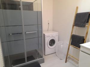 een wasruimte met een wasmachine en een wasmachine bij Logement de 100m2 avec terrasse in Wardrecques