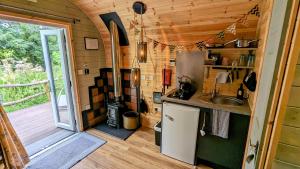 a small kitchen with a sink and a stove at Emlyn's Coppice - Luxury Woodland Glamping in Holywell