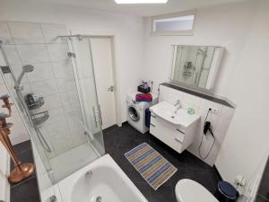 a bathroom with a sink toilet and a shower at Ferienwohnung Pinovas in Friedrichshafen