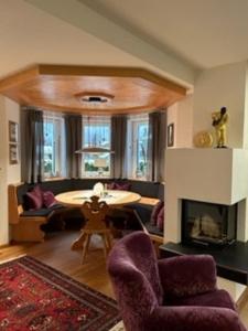a living room with a table and a fireplace at Grossbergblick in Filzmoos