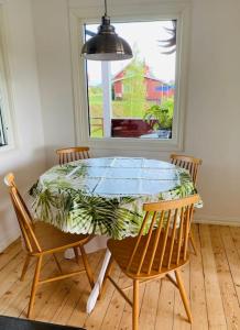 mesa de comedor con 4 sillas y ventana en Trevligt fritidshus med stor terrasse mot sjöen 
