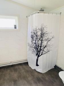 Una cortina con un árbol pintado en una habitación en Trevligt fritidshus med stor terrasse mot sjöen 