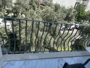 a metal railing on a balcony with trees at Tugay Hotel in Fethiye