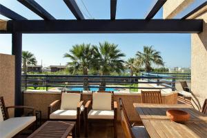 a patio with a table and chairs and a pool at Aires de Doñana. Piscina y Playa. Parking gratis. in Sanlúcar de Barrameda