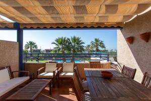 a patio with tables and chairs and a view of the ocean at Aires de Doñana. Piscina y Playa. Parking gratis. in Sanlúcar de Barrameda