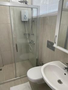 a bathroom with a shower and a toilet and a sink at Tugay Hotel in Fethiye