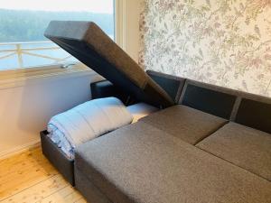 un sofá en una habitación con ventana en Trevligt fritidshus med stor terrasse mot sjöen 