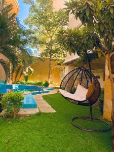 una silla mecedora en un patio junto a una piscina en فيلا مبهجة مع مسبح وحديقة رائعة, en Seis de Octubre