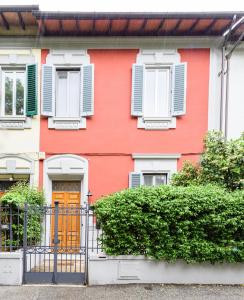 a red house with white windows and a orange door at B&B Casa Rossa in Florence