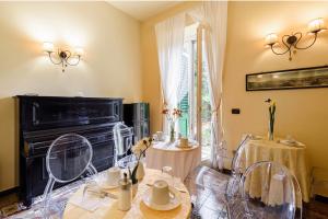 un soggiorno con pianoforte, tavoli e sedie di B&B Casa Rossa a Firenze