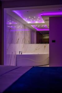 a bathroom with a sink and purple lighting at Rei Lux in Belgrade