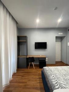 Schlafzimmer mit einem Bett und einem Schreibtisch mit einem TV in der Unterkunft B&B MariLù in Foggia