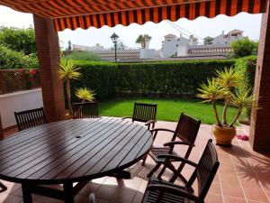 a wooden table and chairs on a patio at MojacarProperty, Apto Mirador Vera Playa in Vera