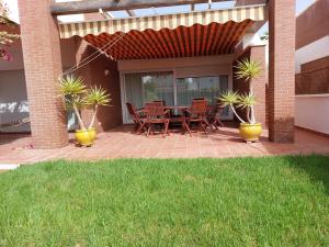 a patio with a table and chairs and plants at MojacarProperty, Apto Mirador Vera Playa in Vera