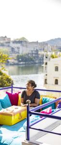 a woman sitting on a bed on a boat at goSTOPS Udaipur in Udaipur
