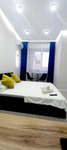 1 dormitorio con 1 cama grande y cortinas azules en Sholpan city studia 137/3, en Almaty