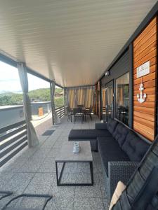 a covered porch with a couch and a table at Mobile Home L&L in Drage