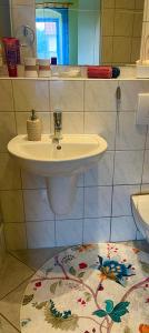 a bathroom with a sink and a rug at Pension Petersohn (ehem. Zur Heimat) in Klausdorf Brandenburg