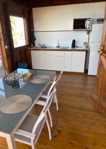 uma cozinha com uma mesa e cadeiras e um frigorífico em Bungalows Lanar'am Kaladja -1 em Bouillante