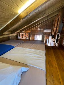 two beds in a room with wooden floors at Bungalows Lanar'am Kaladja -1 in Bouillante