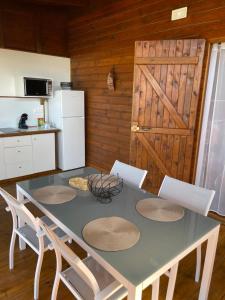 uma cozinha com uma mesa com cadeiras e um frigorífico em Bungalows Lanar'am Kaladja -1 em Bouillante