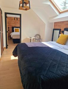 a bedroom with a large bed with a black blanket at Hotel L'ermitage in Houffalize