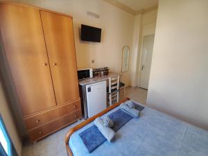 Habitación pequeña con cama y cocina en Studios IRENE en Fourni Ikarias