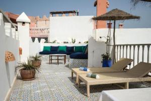 eine Terrasse mit Stühlen und Tischen auf dem Balkon in der Unterkunft Riad l'Ayel d'Essaouira in Essaouira