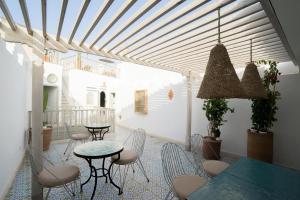 un patio con tavoli, sedie e soffitto di Riad l'Ayel d'Essaouira a Essaouira