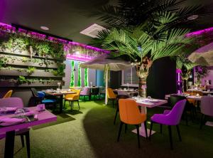 a restaurant with tables and chairs and a palm tree at La Bussola Hotel Calabria in Capo Vaticano