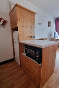 eine Küche mit einer Theke und einer Mikrowelle in der Unterkunft Studio 4 personnes à La Rosière in Montvalezan
