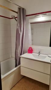ein Badezimmer mit einem Waschbecken, einer Badewanne und einem Spiegel in der Unterkunft Studio 4 personnes à La Rosière in Montvalezan