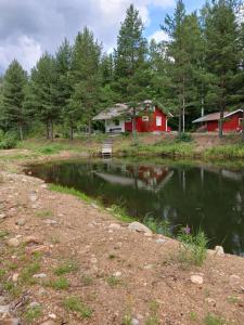 un estanque con un banco frente a una casa roja en Perälampi, en Huissi