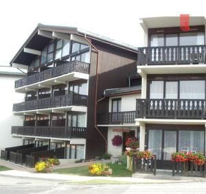 ein Apartmenthaus mit Balkonen und Blumen davor in der Unterkunft Studio 4 personnes à La Rosière in Montvalezan