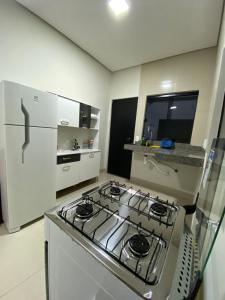 uma cozinha com um fogão e um frigorífico em Flat Davisis 3 - PX da JK em Palmas