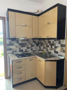 a kitchen with wooden cabinets and a stove top oven at Guest House Lionel in Durrës