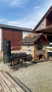 a picnic table and a grill next to a building at Pełnikowe Zacisze in Bobolice
