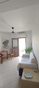 1 dormitorio con 2 camas, mesa y mesa en Theros Apartments en Mirina