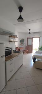 a kitchen with white cabinets and a counter top at Theros Apartments in Myrina