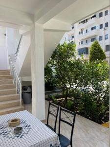 a table and chairs on a balcony with a building at Guest House Lionel in Durrës +28 photos