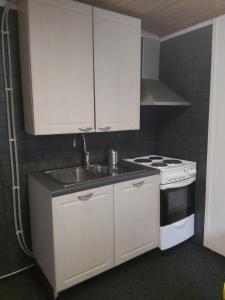 a kitchen with white cabinets and a sink and a stove at "Beach" Asunto Ilmastointilaitteella ja Älylukolla in Imatra