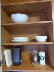 a cupboard with plates and bowls and a coffee maker at "Beach" Asunto Ilmastointilaitteella ja Älylukolla in Imatra +5 photos