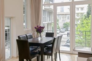 uma sala de jantar com uma mesa e cadeiras e uma janela em TiflisLux Apartment em Tbilisi