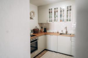 a white kitchen with white cabinets and a sink at Usedlost Jindřichovice 